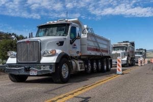 Sunroc Dump Trucks lined up to Delivery Hot Asphalt on SR-12 Near Bryce Canyon Utah